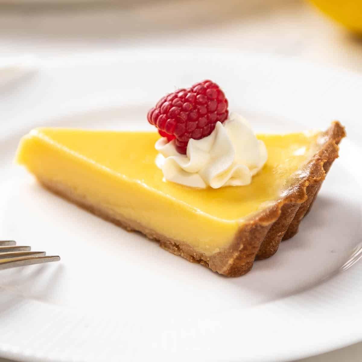 Close-up of a slice of lemon custard tart with a creamy yellow filling and golden-brown crust