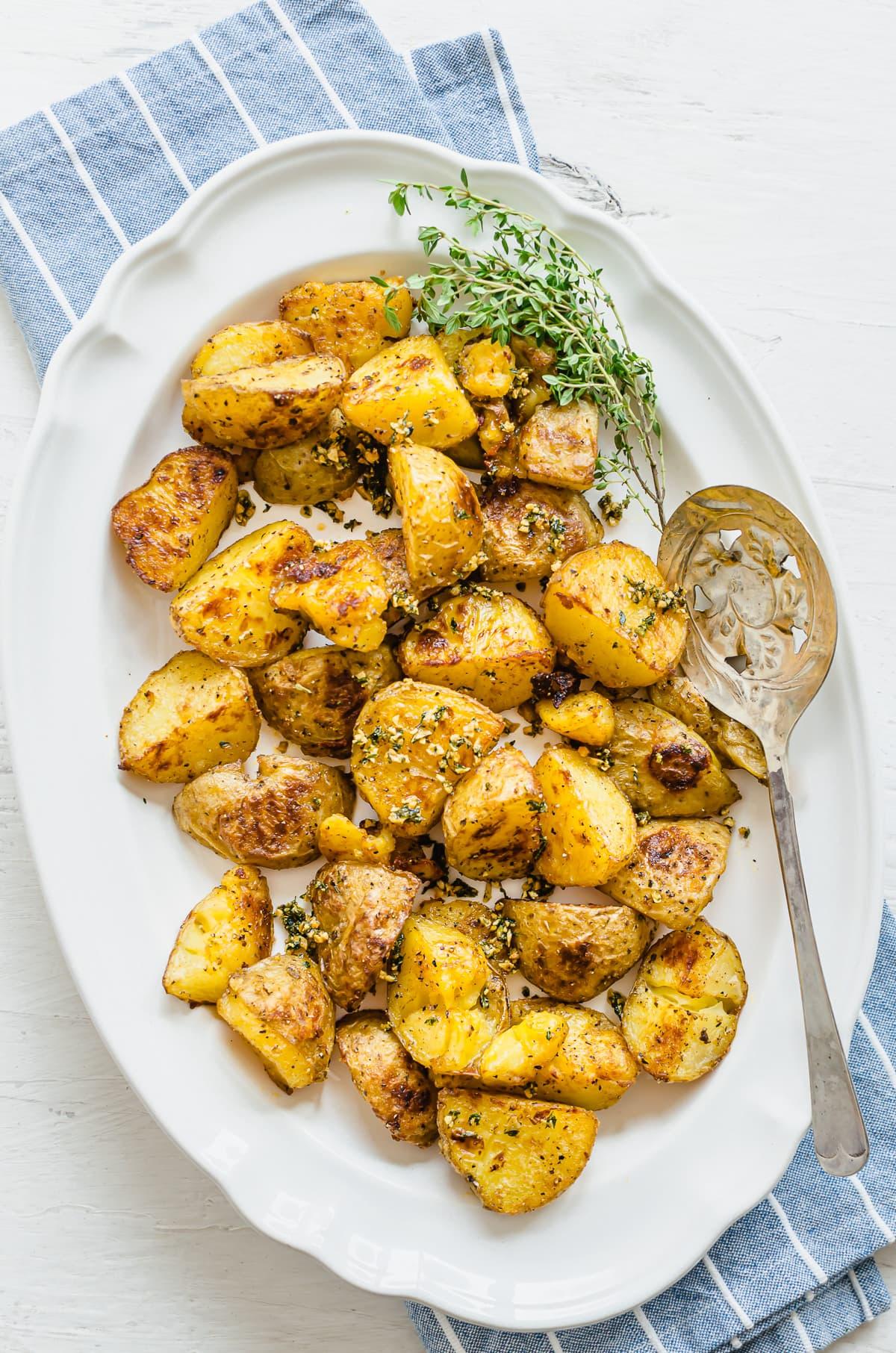 Close-up shot of golden brown roasted potatoes with fresh herbs