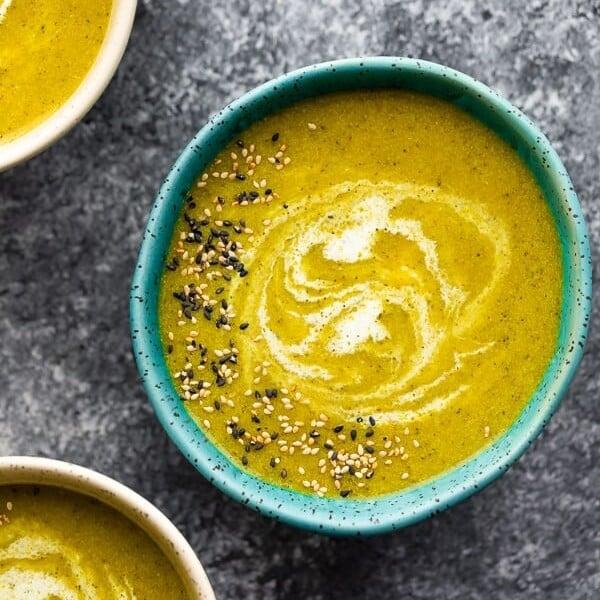 overhead shot of a pot of simmering broccoli and ginger soup on a stovetop