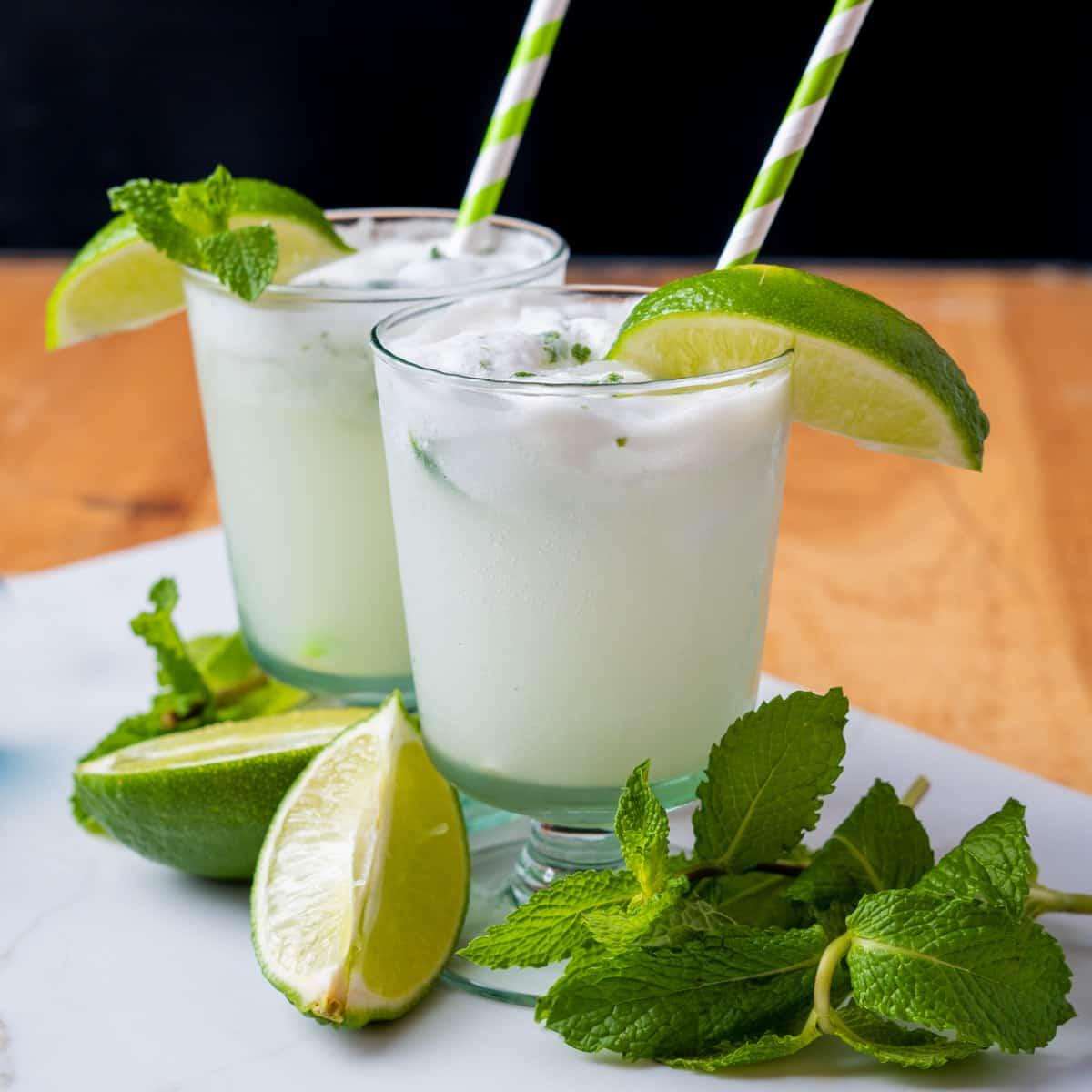 fresh mint leaves, lime wedges, and coconut cream arranged for a mojito cocktail