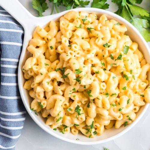 creamy pasta mac bowl with golden cheese, fresh parsley, and steam rising