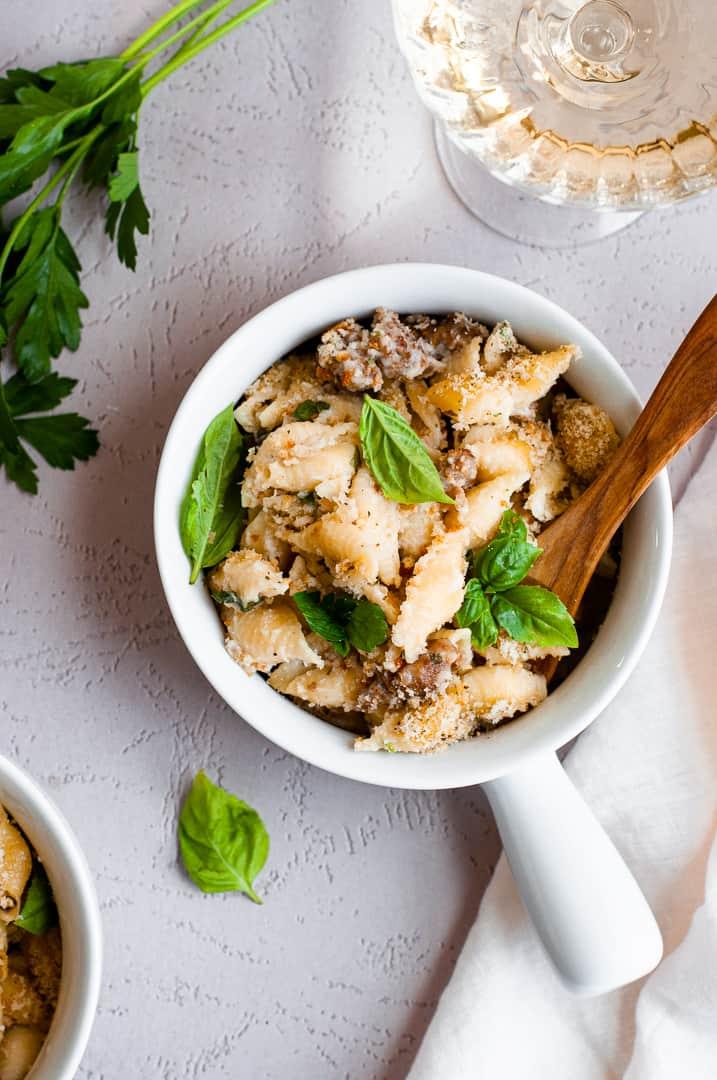 Vibrant, bubbling Italian mac and cheese in a rustic pot, garnished with fresh basil leaves and a sprinkle of Parmesan
