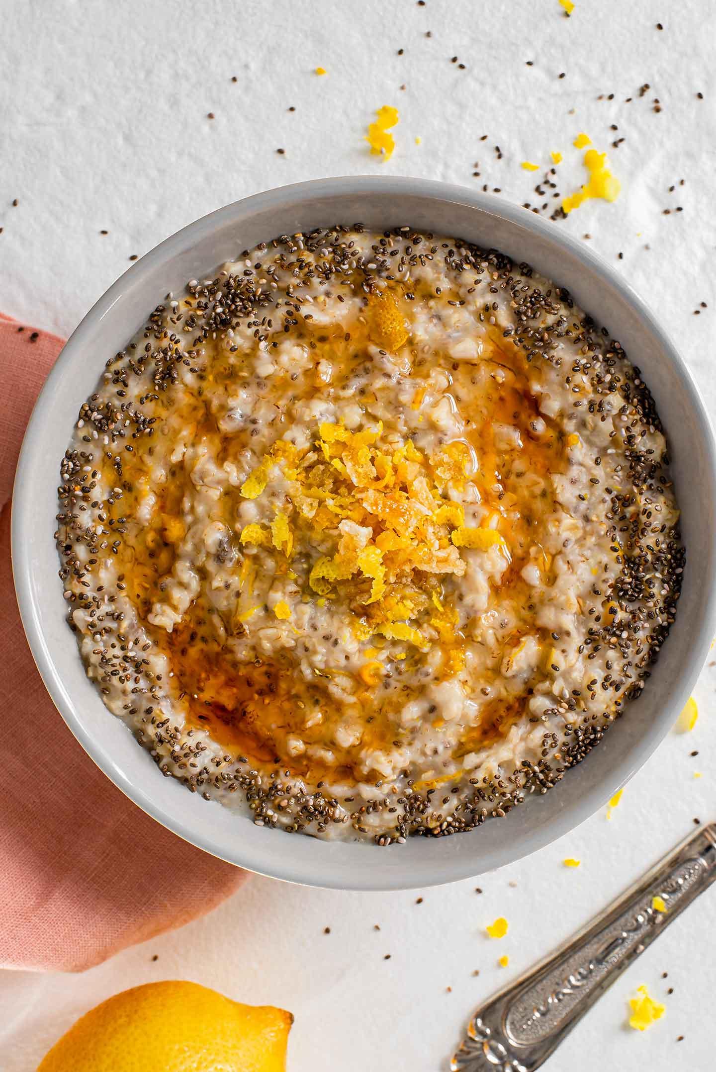 close-up shot of lemon zest being added to a bowl of cooked oatmeal