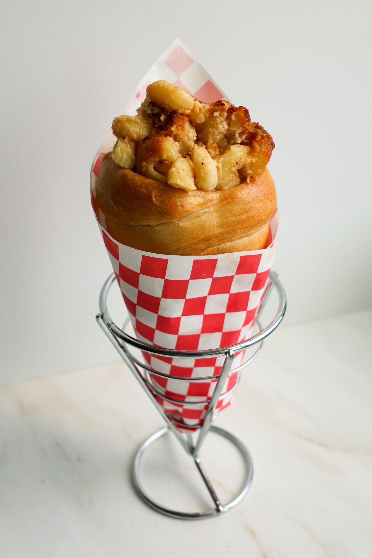 hands shaping mac and cheese with a piping bag