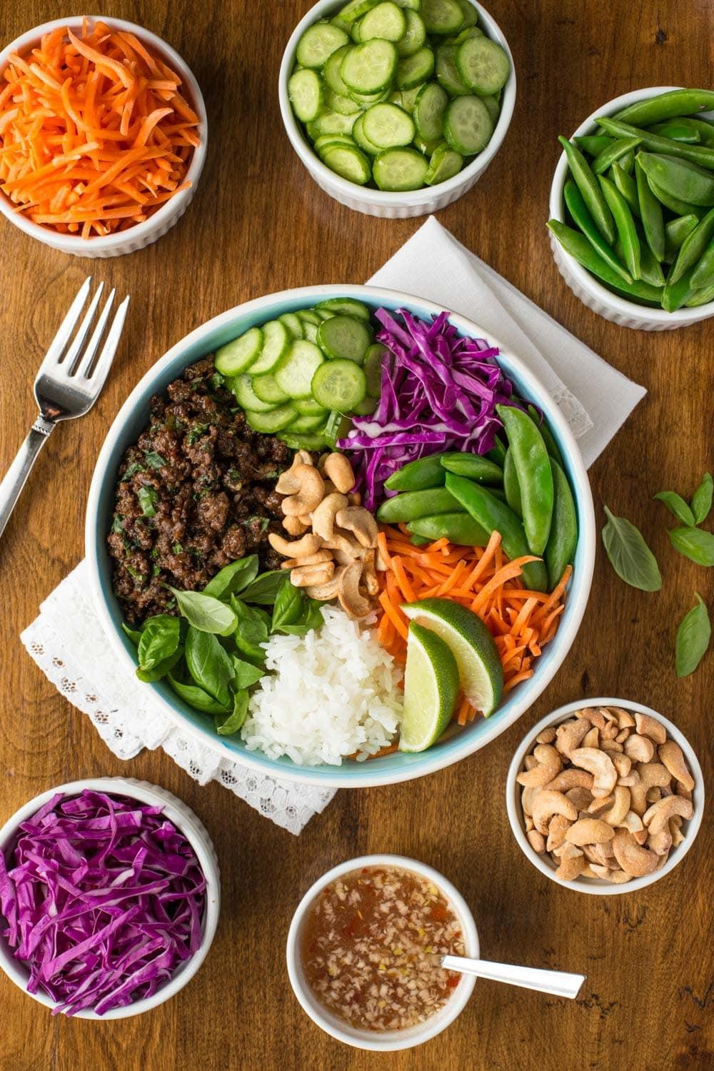Overhead view of a colorful Thai Basil Beef Rice Bowl with garnishes