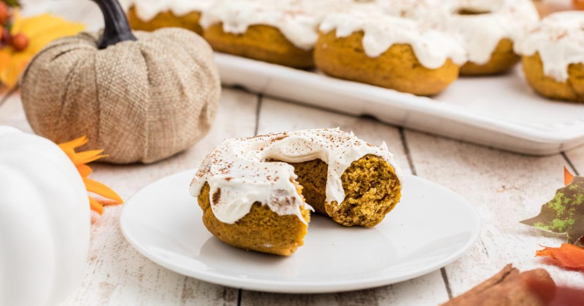 Close-up of a pumpkin spice latte steamed doughnut being bitten into, showing the soft interior