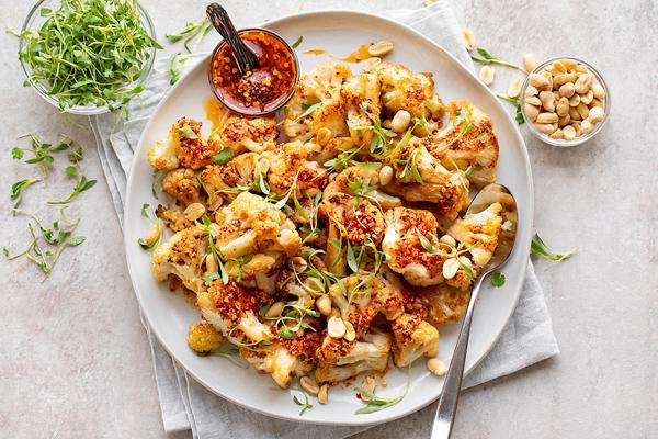 crispy chili glazed cauliflower with festive holiday decorations, close-up, appetizer spread