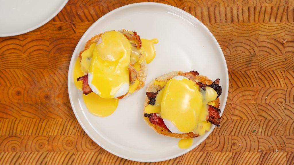 Close up of a finished Eggs Benedict dish with hollandaise sauce