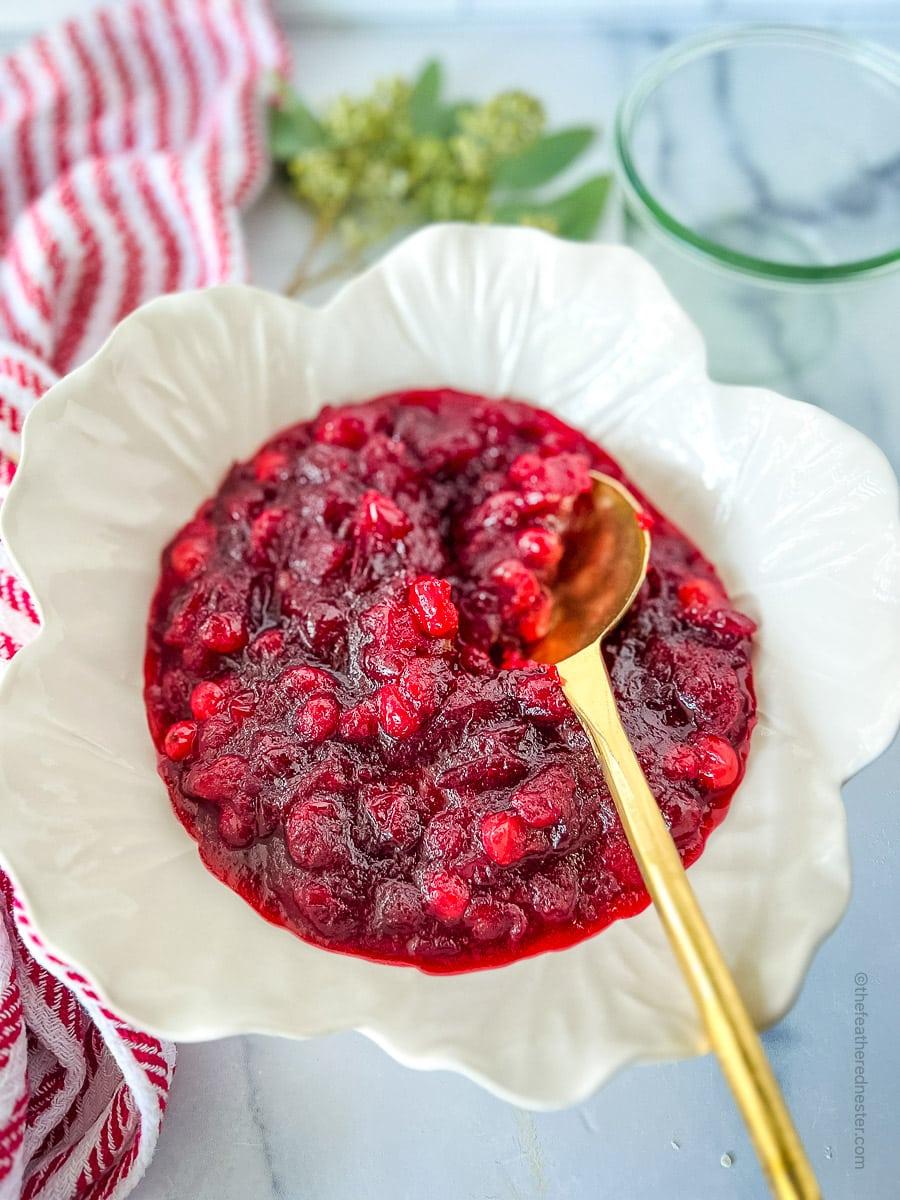 Cranberry sauce in a serving bowl with a spoon, ready to be served
