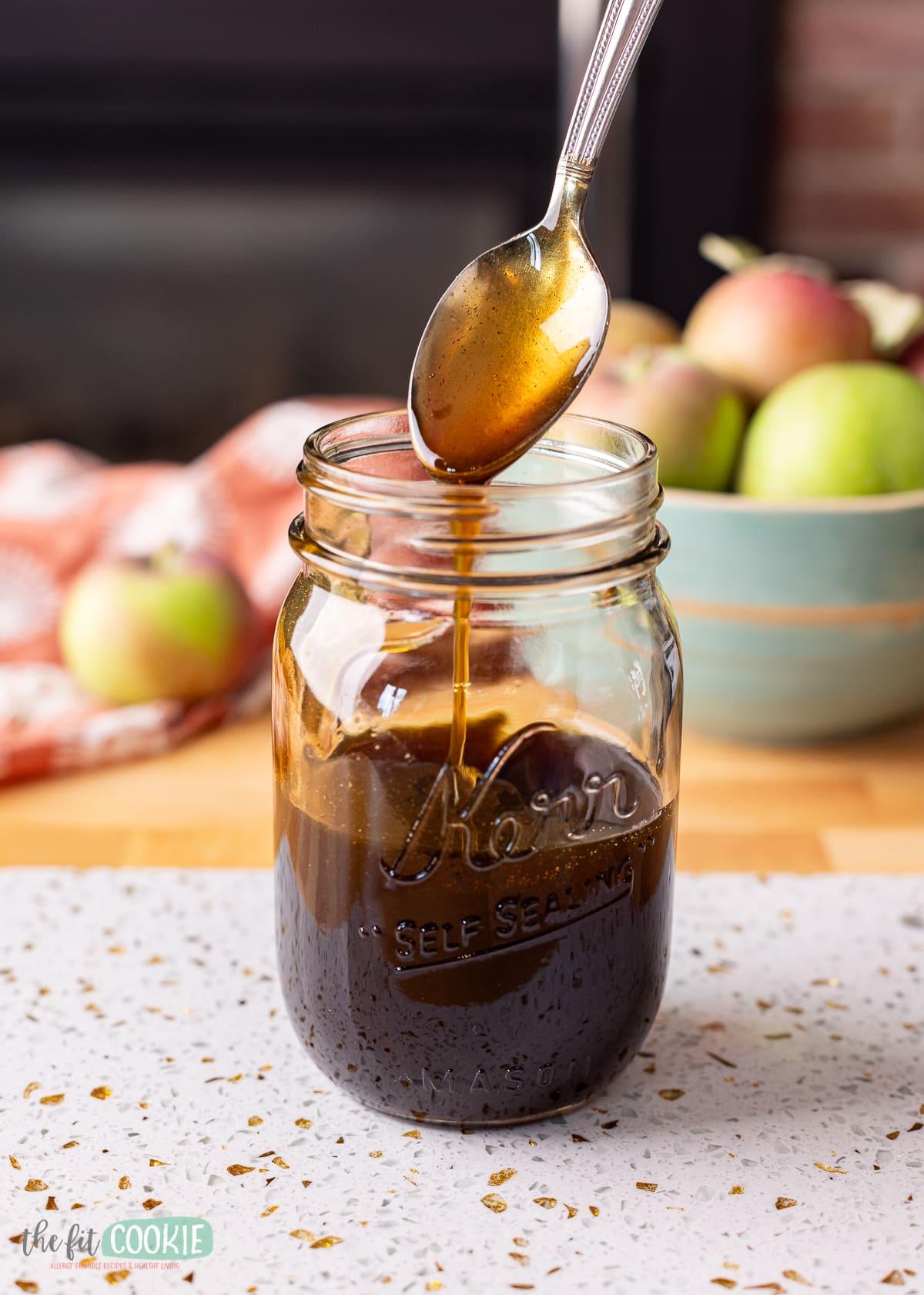 A golden-brown apple crisp with a drizzle of dark amber tequila syrup