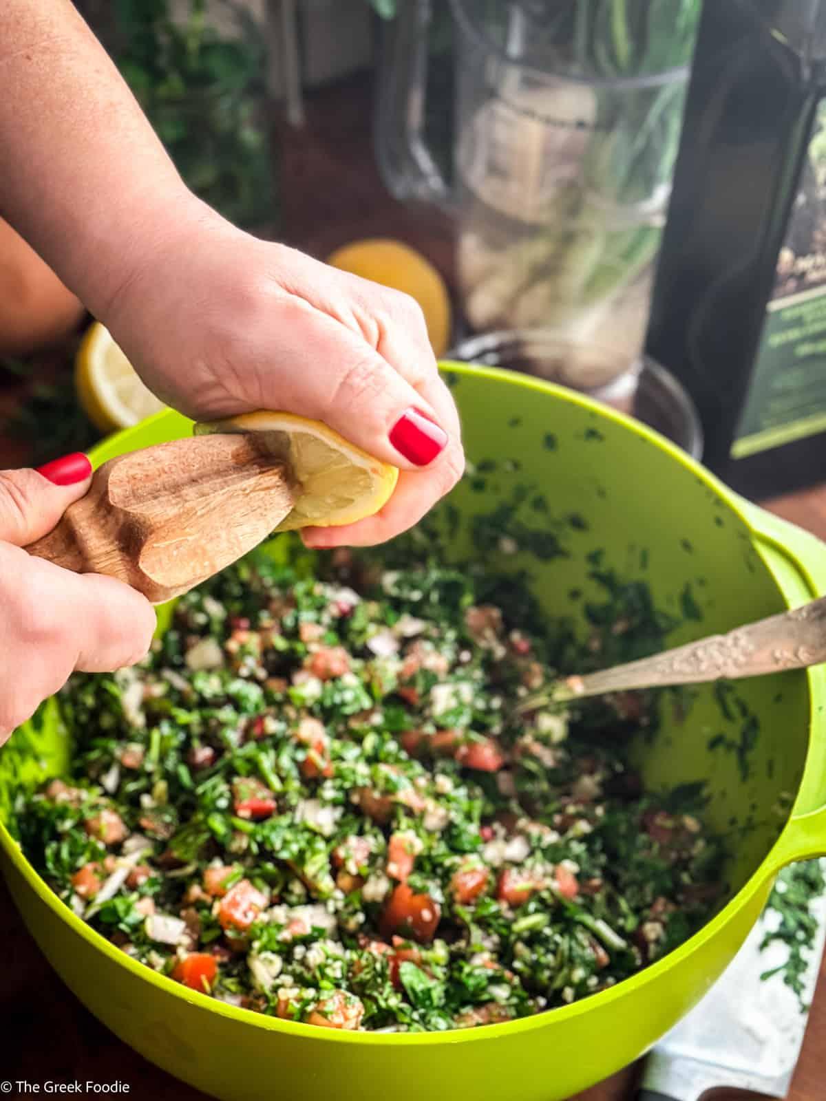 hands preparing tabbouleh with fresh ingredients