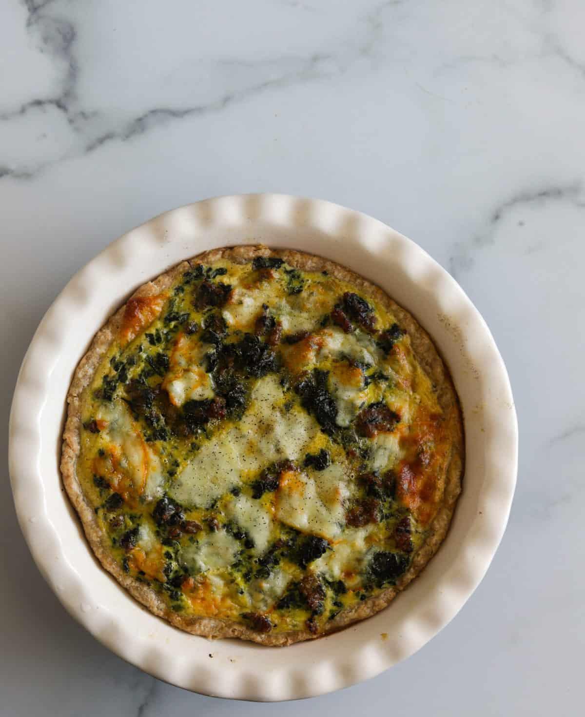 Overhead shot of a freshly baked sausage and spinach quiche