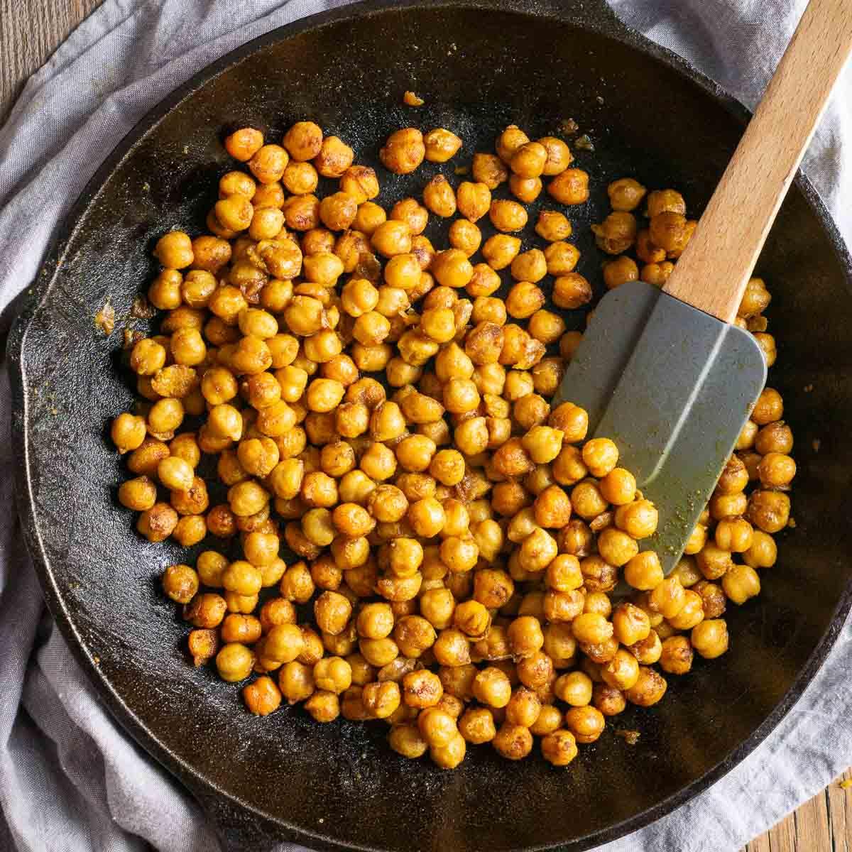 Close-up of chickpeas being cooked with turmeric and spices