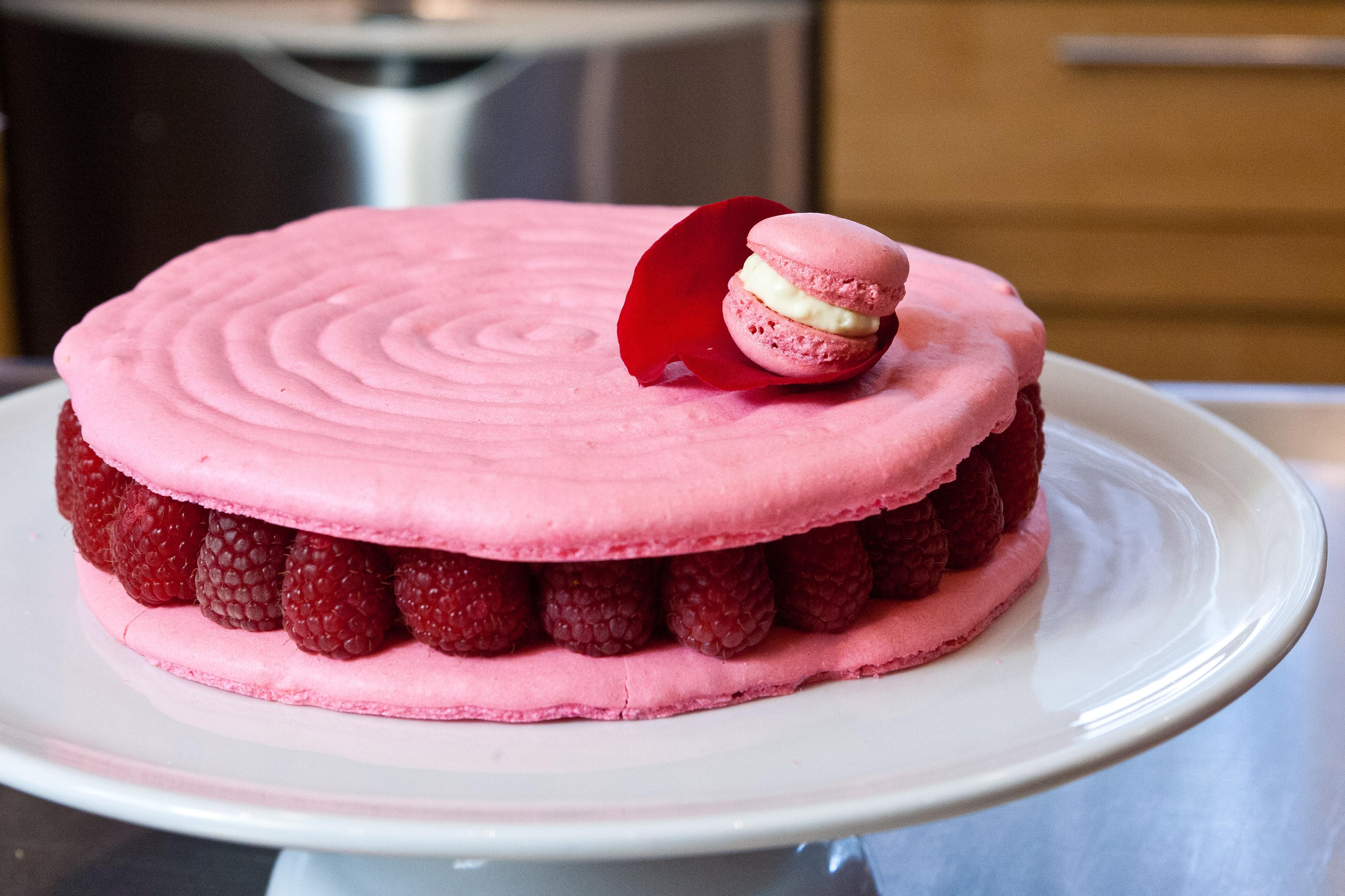 raspberry rose macaroon cake with a slice taken out