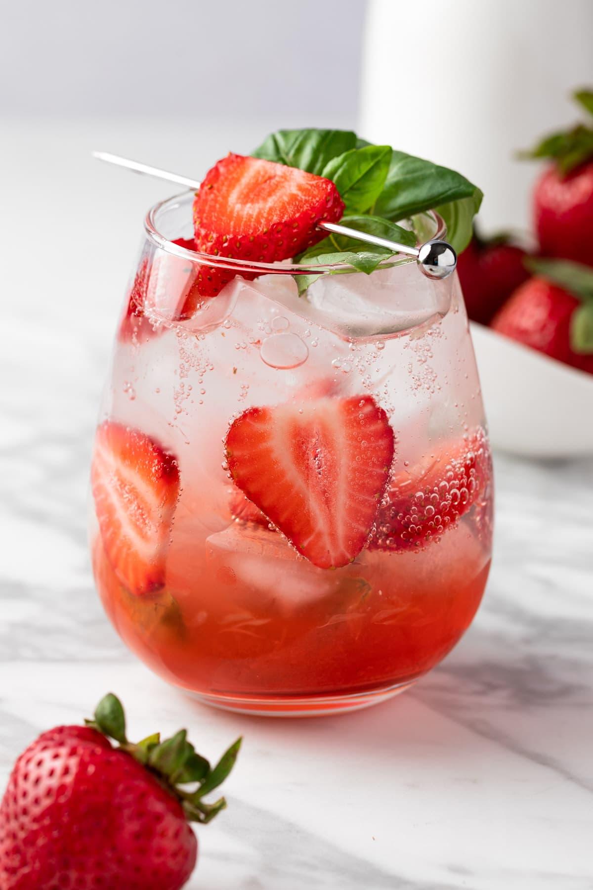 Basil Strawberry Mimosa garnished with fresh basil and strawberries