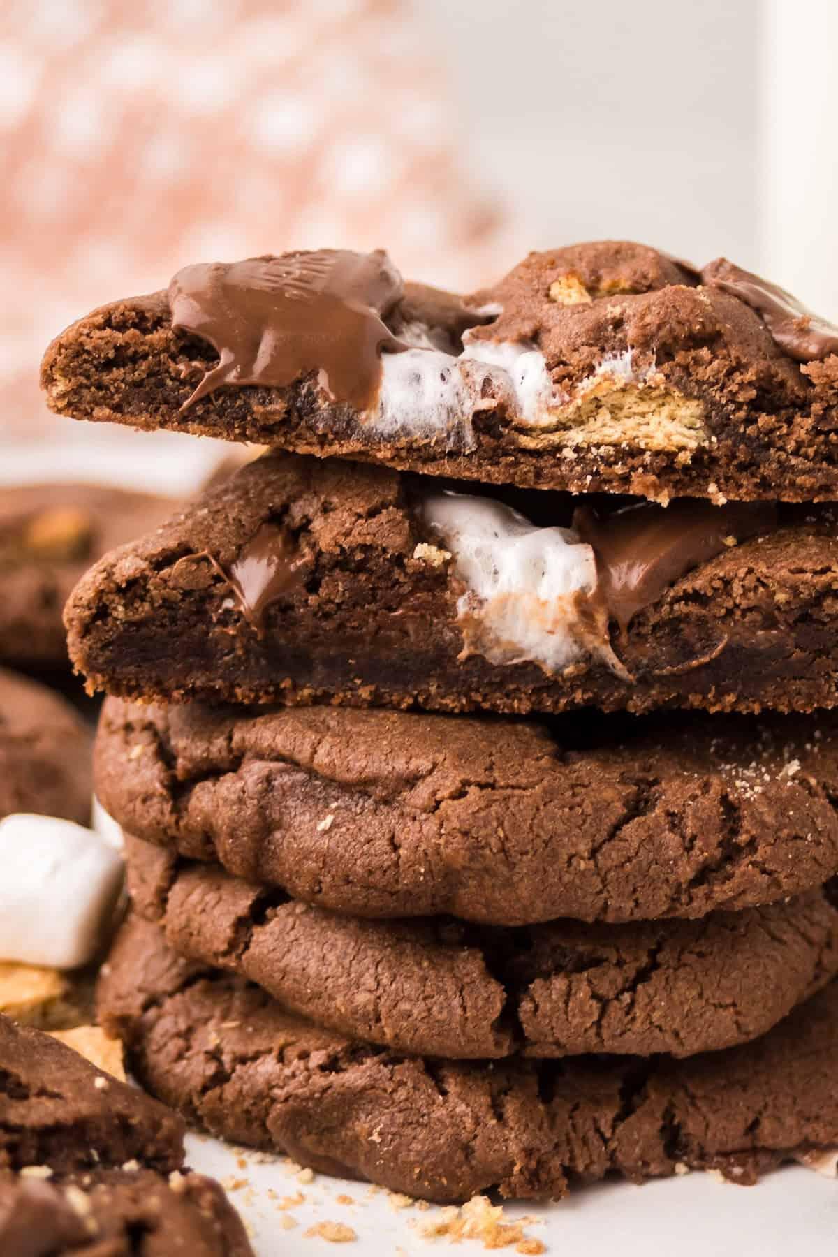stack of freshly baked chewy double chocolate cookies on a cooling rack, some with melted chocolate chips visible