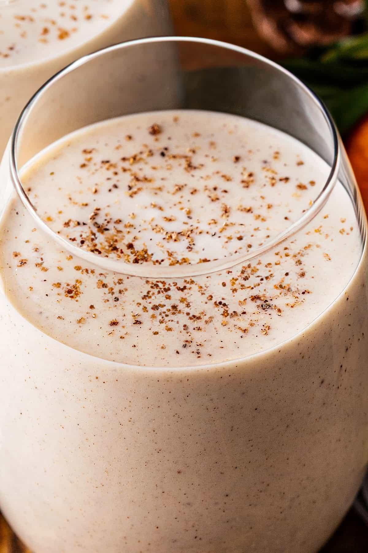 Close-up of Coquito being blended in a high-speed blender, creating a smooth, creamy texture