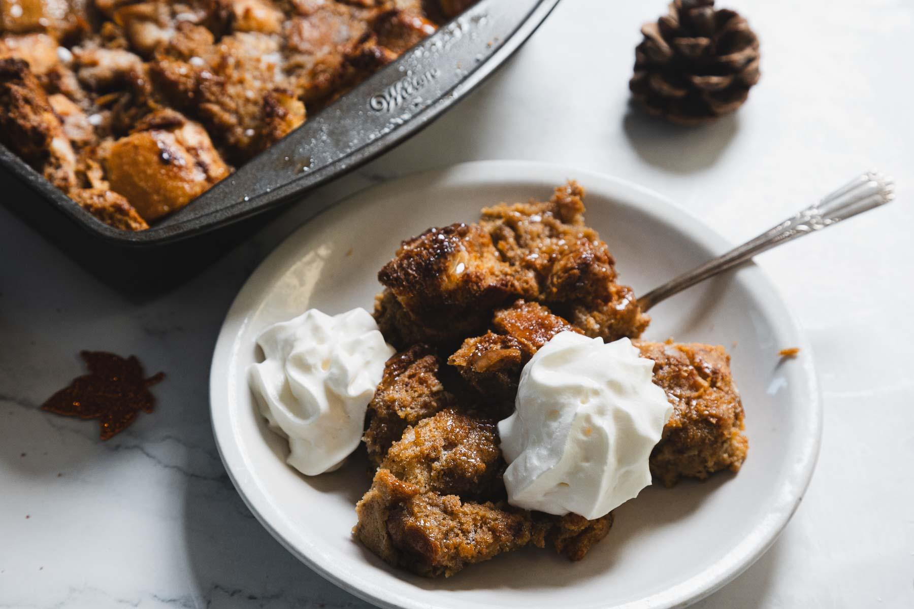A warm and inviting gingerbread casserole, golden-brown and topped with a creamy glaze, served in a rustic setting.