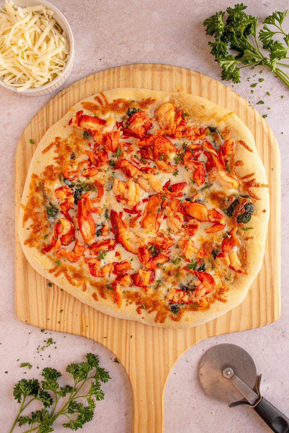 ingredients for lobster pizza laid out on a wooden table