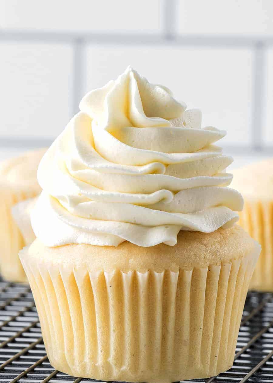 A close up shot of a single vanilla bean cupcake with frosting
