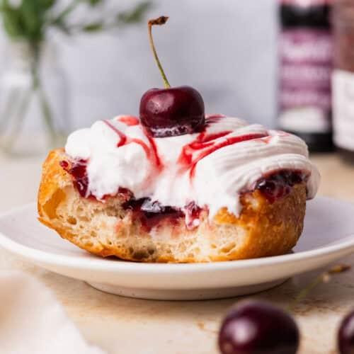 Cherry pie donuts displayed on a wooden platter, showcasing the cherry filling and glaze