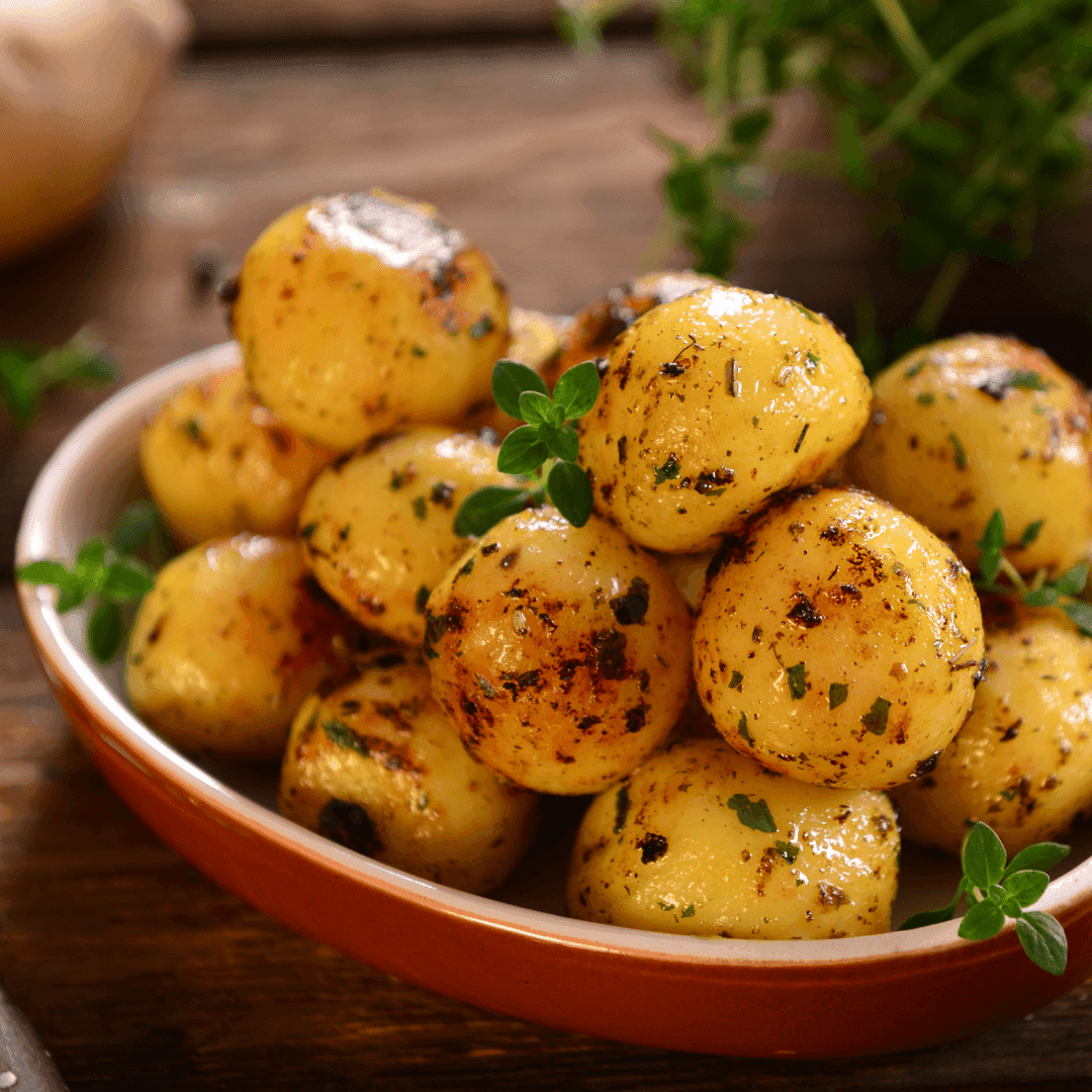 Close-up of boiled potatoes being seasoned with spices