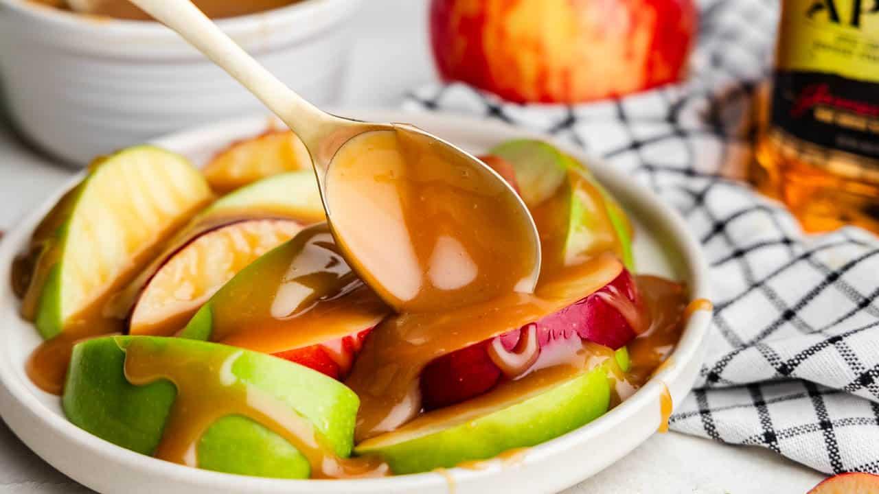 Close-up of caramel drizzle over sliced apples in a punch bowl
