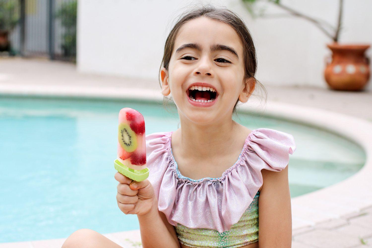 child happily eating a fruit ice pop