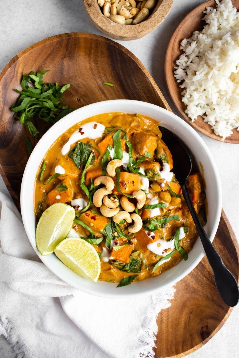 Overhead shot of simmering sweet potato coconut curry in a pot with steam rising