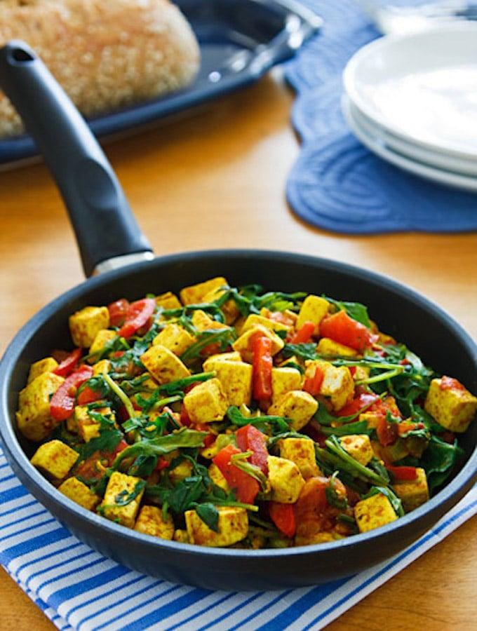 Black truffle tofu scramble with arugula in a skillet