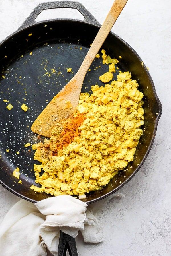 close up of gyro spiced tofu scramble being cooked in a pan