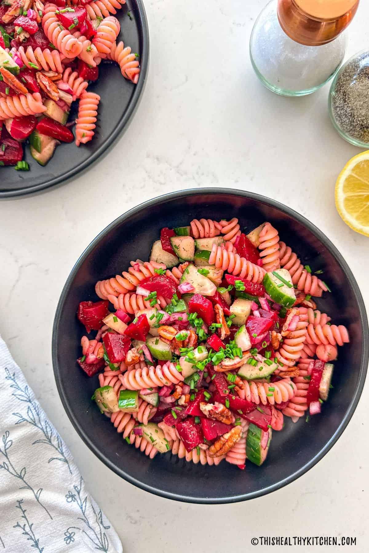 bowl of beet pasta salad with dill garnish