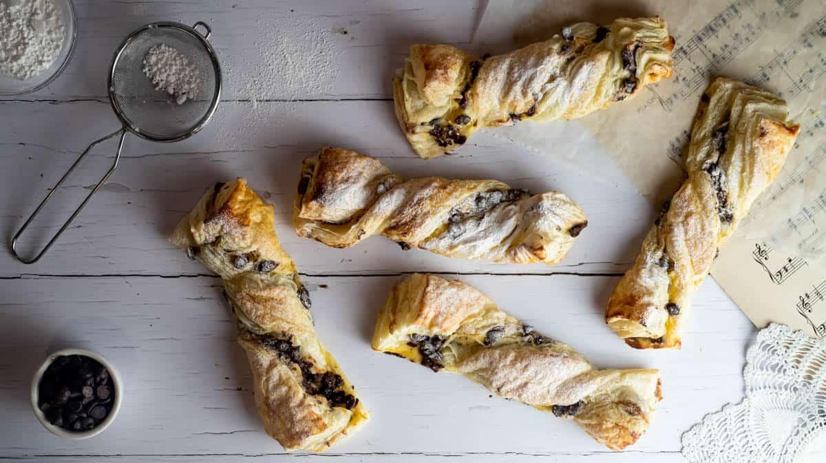 Overhead shot of freshly baked golden puff pastry twists cooling on a wire rack