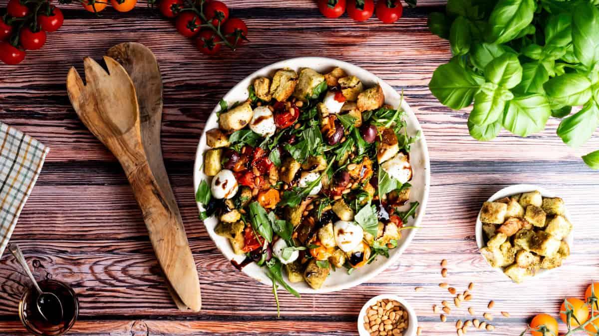 an overhead view of the salad in a rustic bowl, surrounded by the fresh ingredients used in the recipe