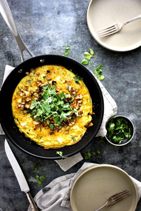 whole Jalapeño Popper Frittata in a skillet, garnished with chives