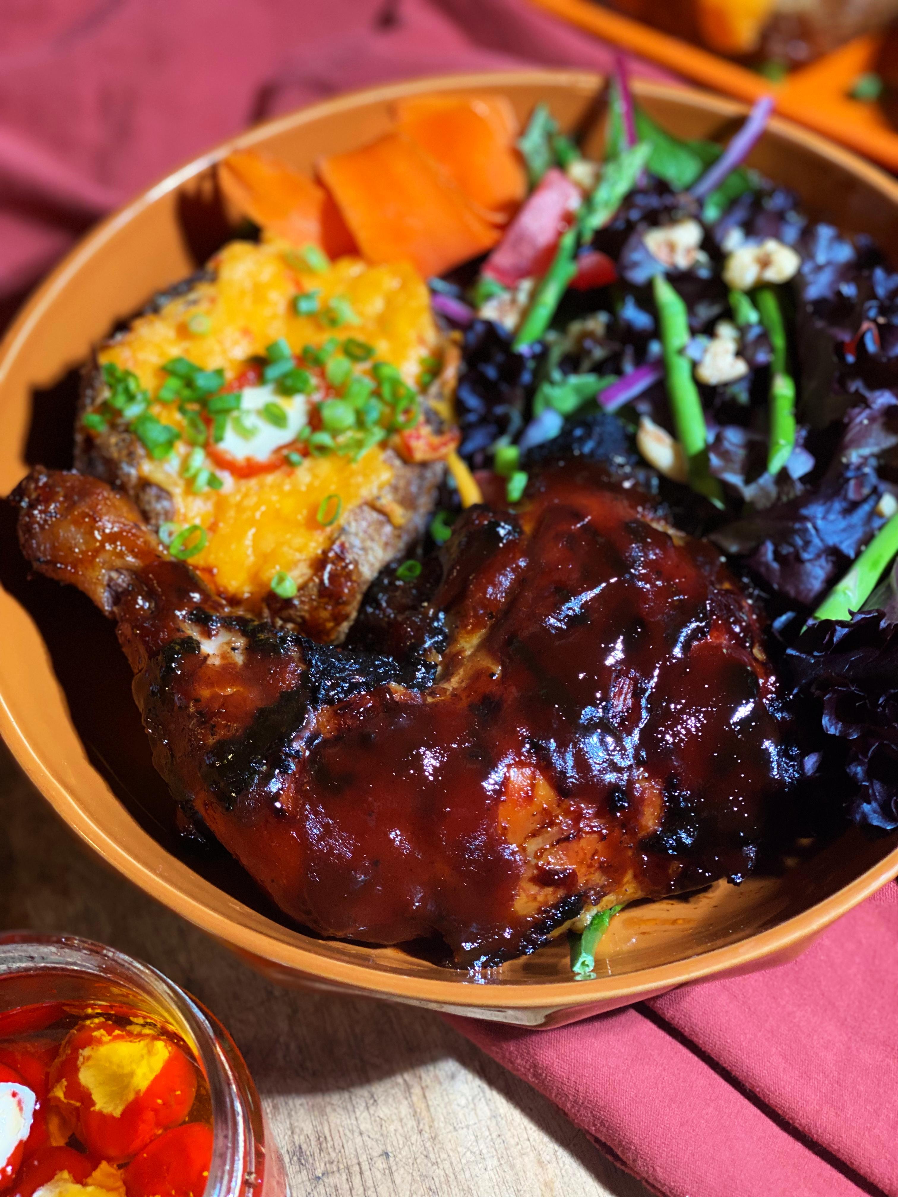 Overhead shot of a plate with grilled BBQ chicken and BBQ potatoes