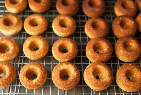 Close-up of a batch of nutmeg bourbon donuts being glazed.