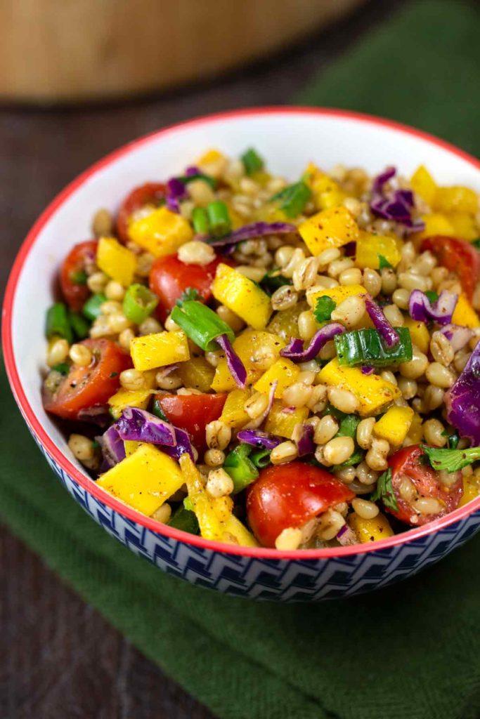 Close up shot of a vibrant wheat berry salad with fresh herbs and vegetables