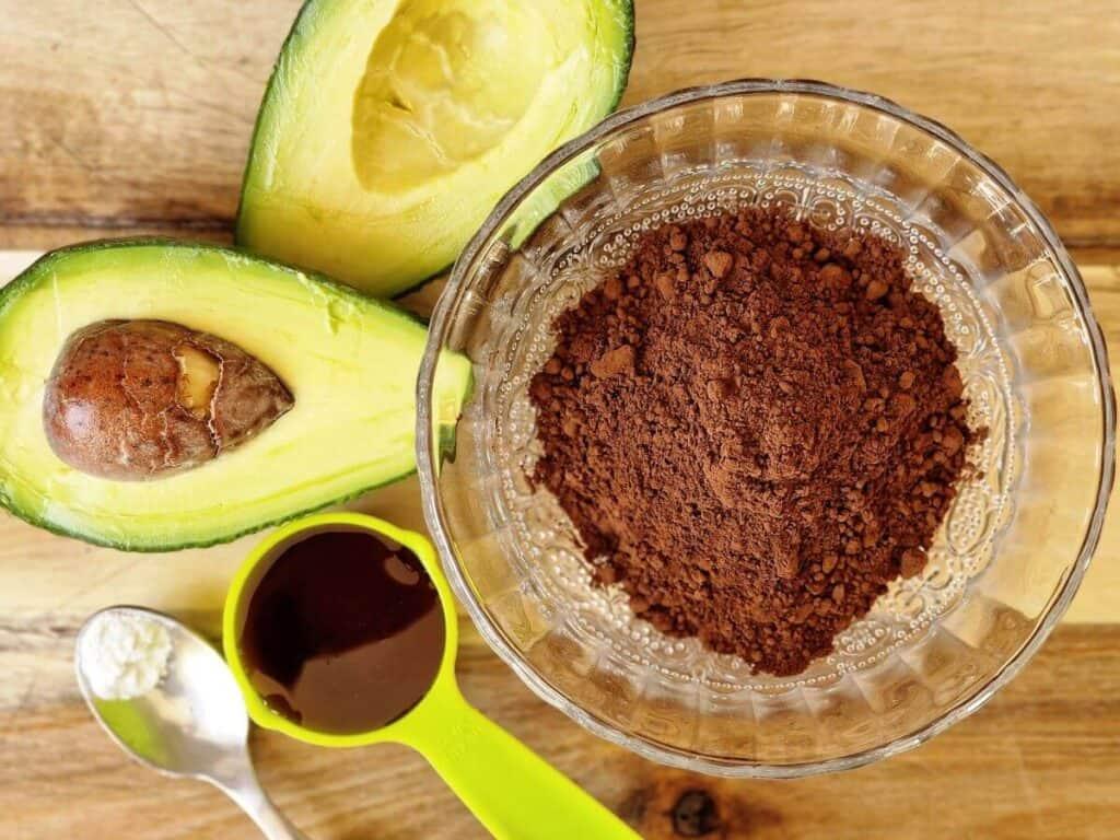 ingredients for avocado chocolate on a wooden countertop