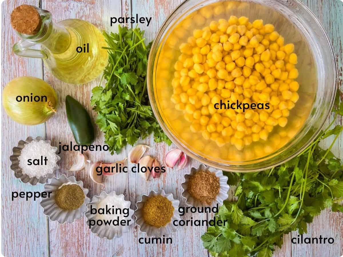 ingredients for falafel laid out on a wooden table, chickpeas, herbs, spices