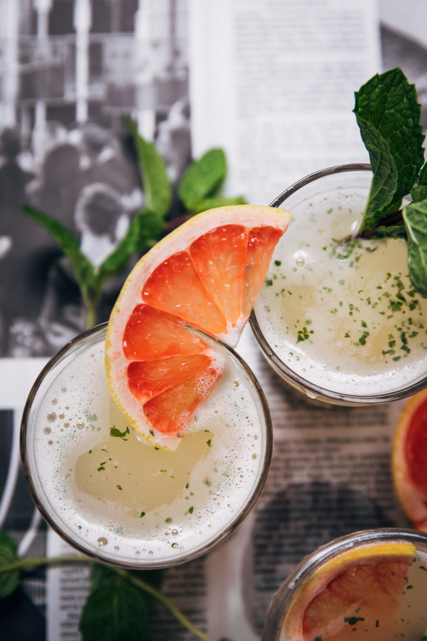pitcher of homemade grapefruit lemonade with grapefruit slices and mint garnish