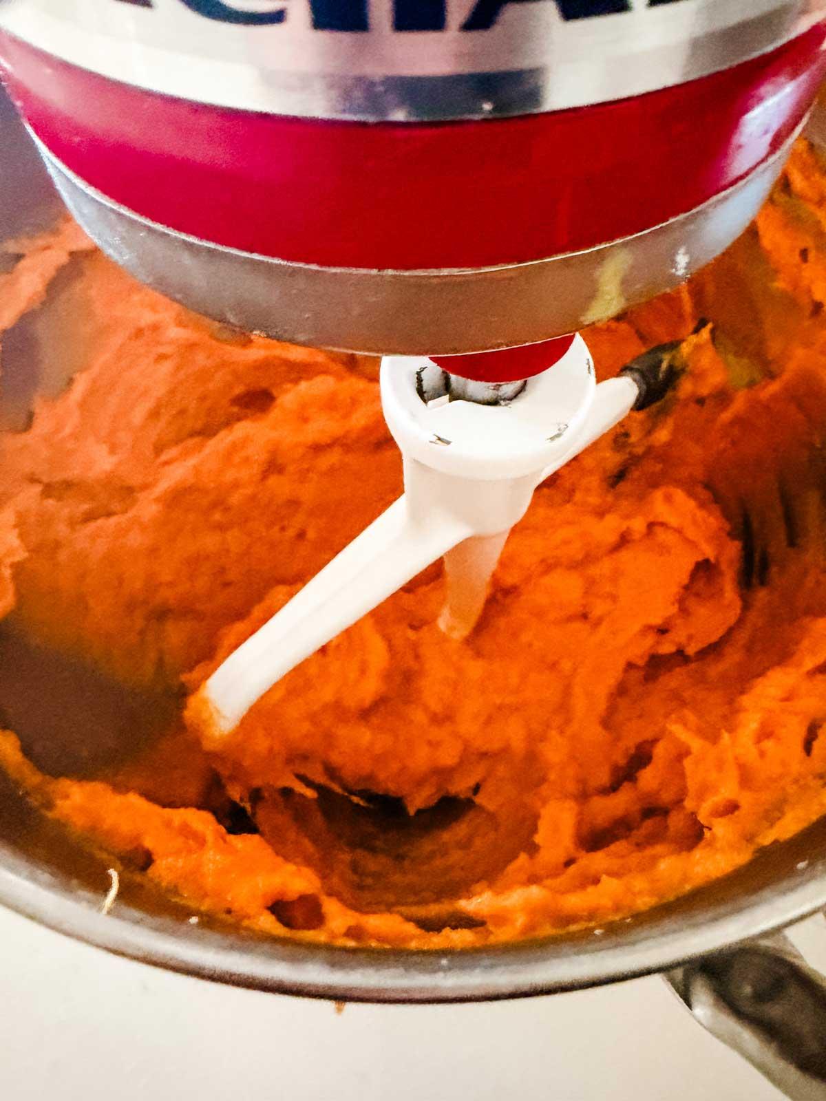 close-up of mashed sweet potatoes being mixed in a bowl