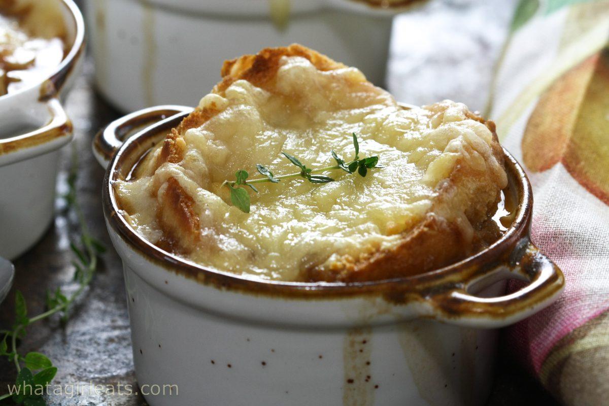 close up shot of classic french onion soup with melted gruyere cheese and crusty bread