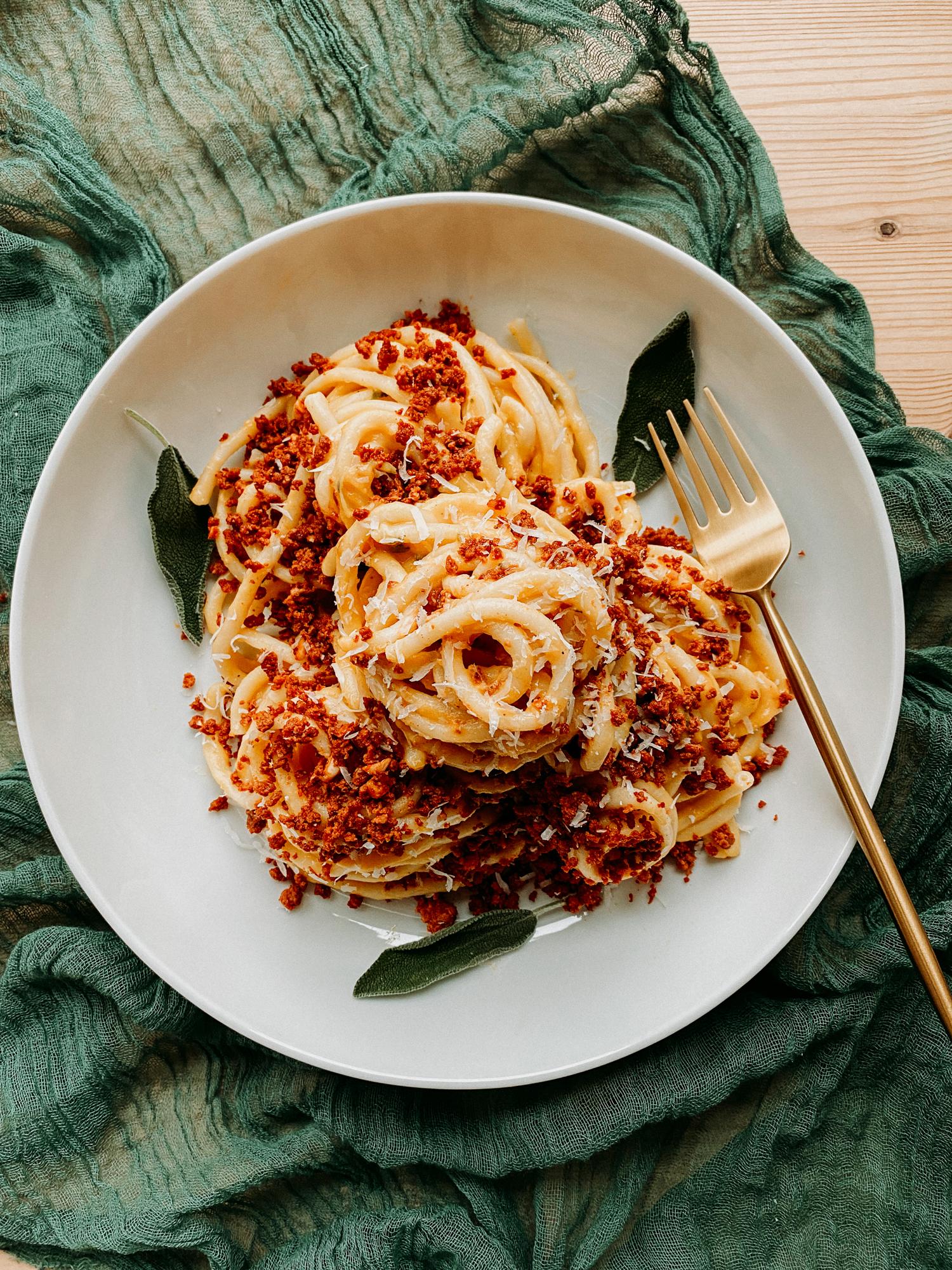 Butternut squash pasta with chorizo and black beans in a rustic bowl