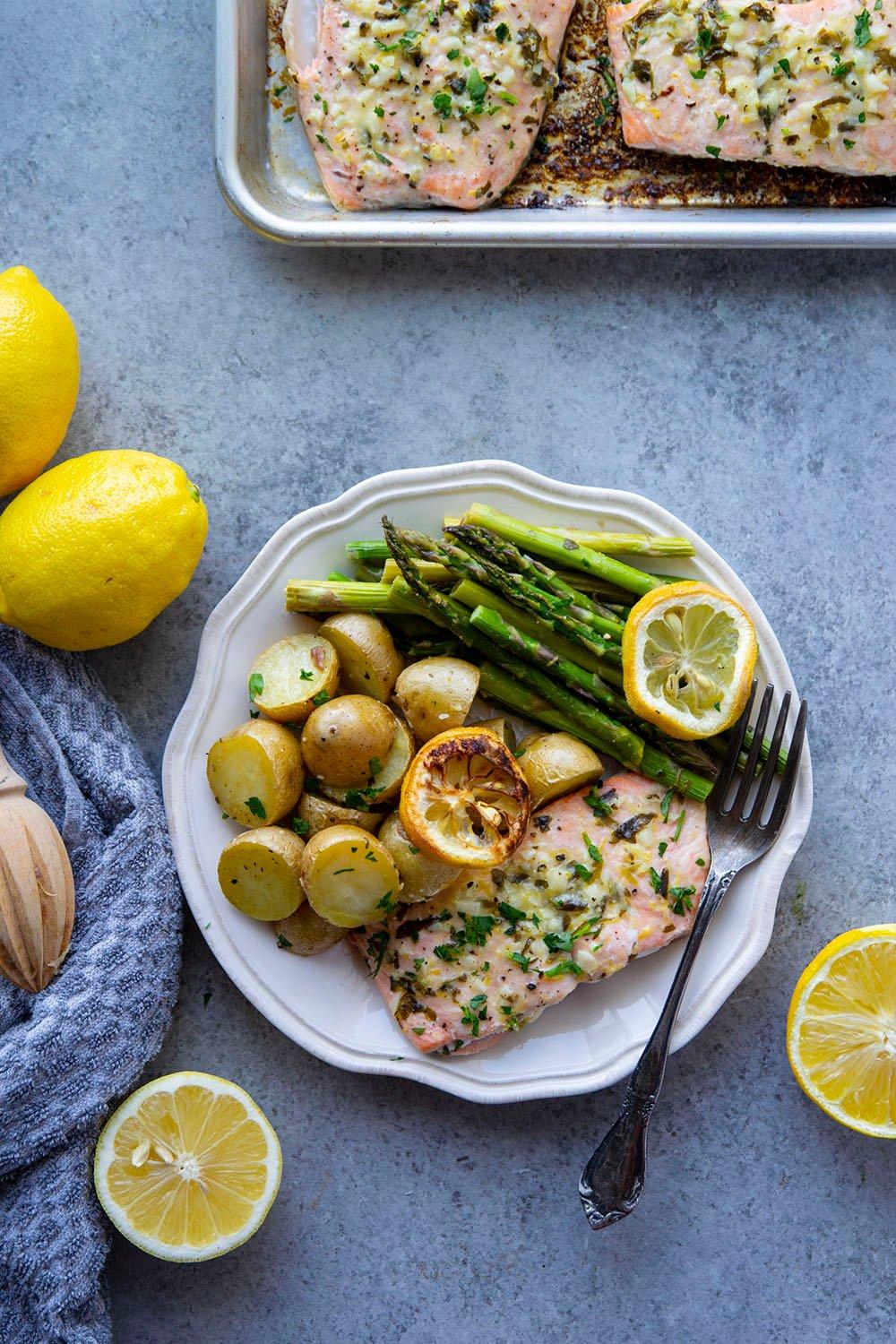 beautifully baked lemon garlic salmon fillets with roasted asparagus on a plate