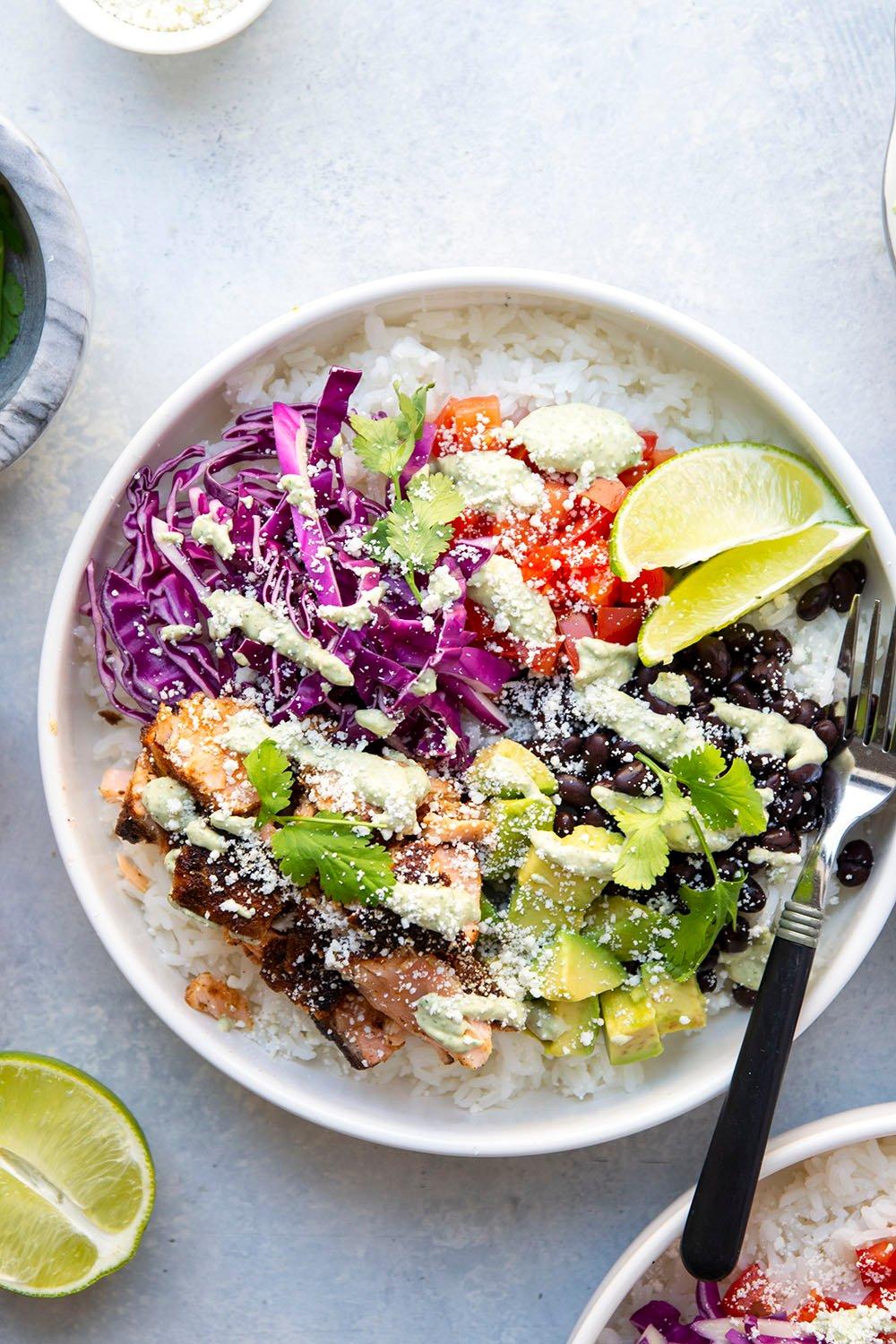 overhead shot of completed blackened fish rice bowl with lime wedge and cilantro garnish.