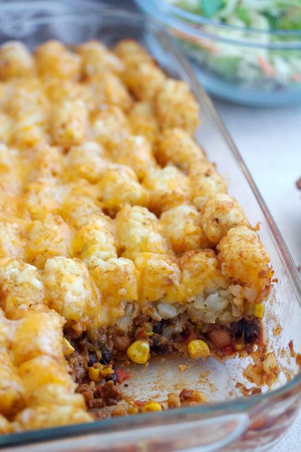 A close-up shot of a warm, bubbling cowboy casserole, fresh out of the oven, with a rustic kitchen background.