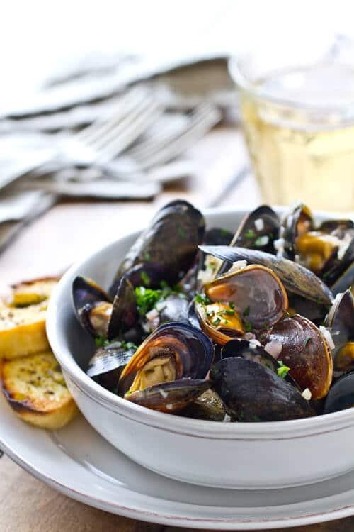 A person enjoying a bowl of garlic herb sauteed mussels
