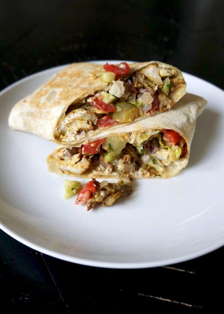 close-up shot of a shawarma wrap being drizzled with tahini sauce