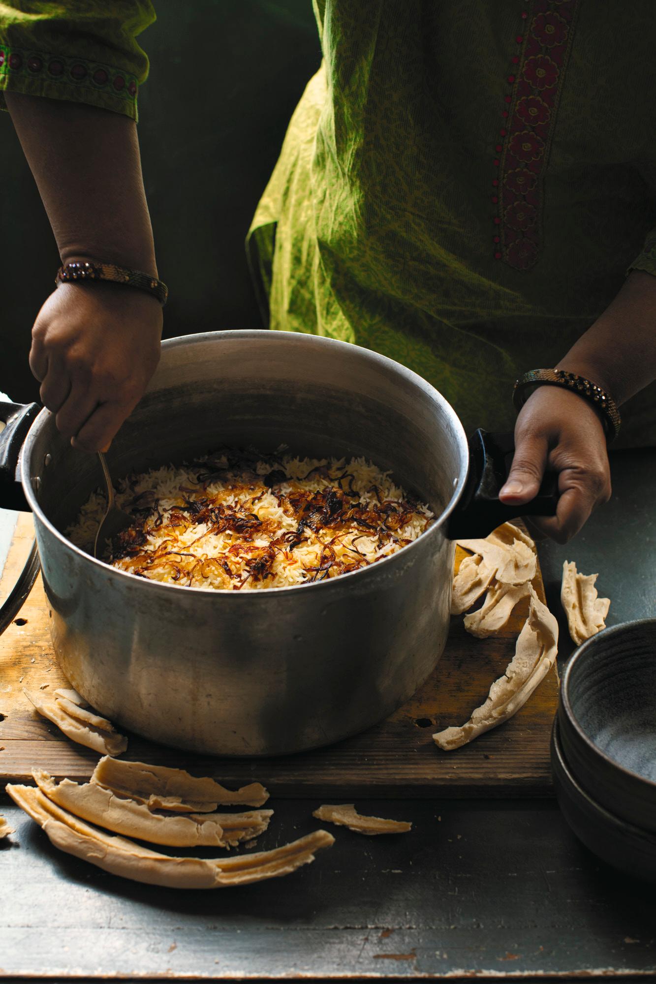 biryani rice being stirred in a large pot